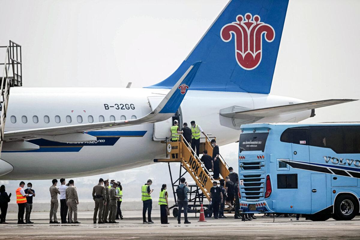 Scam center workers and victims from China handed over from Burma board a plane at Mae Sot Airport in Mae Sot, Thailand, on Feb. 20, 2025. (Lillian Suwanrumpha/AFP via Getty Images)