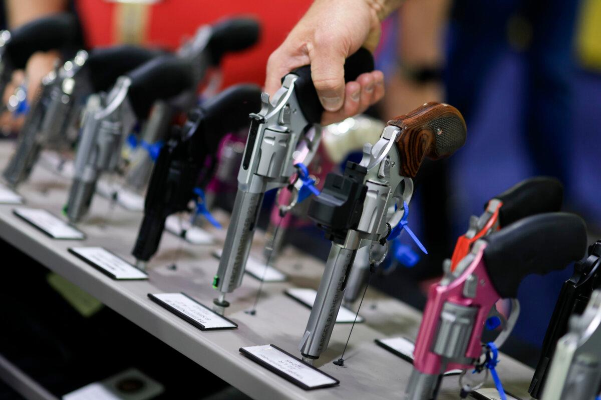 A visitor picks up a revolver at the Charter Arms booth at the 2025 NRA Annual Meetings & Exhibits held in the Georgia World Congress Center in Atlanta, Ga., on April 25, 2025. (Joe Raedle/Getty Images)
