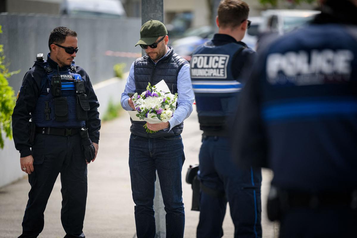 A man holds flowers at Notre-Dame de Toutes-Aides high school the day after a knife attack in which one student was killed and three others wounded in Nantes, France, on April 25, 2025. (Loic Venance / AFP via Getty Images)