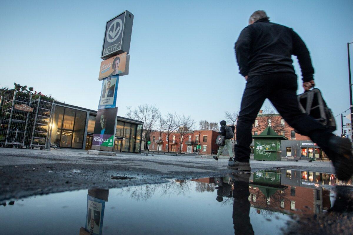 People walk past election signs for various political parties in Montreal ahead of the opening of polls in Canada's federal election on April 28, 2025. (Alexis Aubin/AFP via Getty Images)
