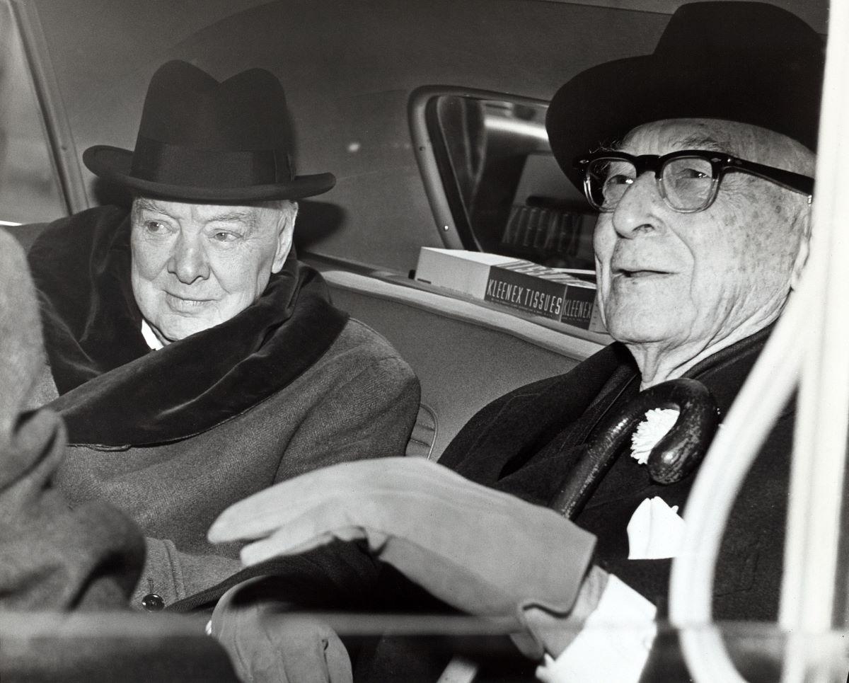 Winston Churchill and Bernard Baruch converse in the back seat of a car in front of Baruch's home. (Public Domain)