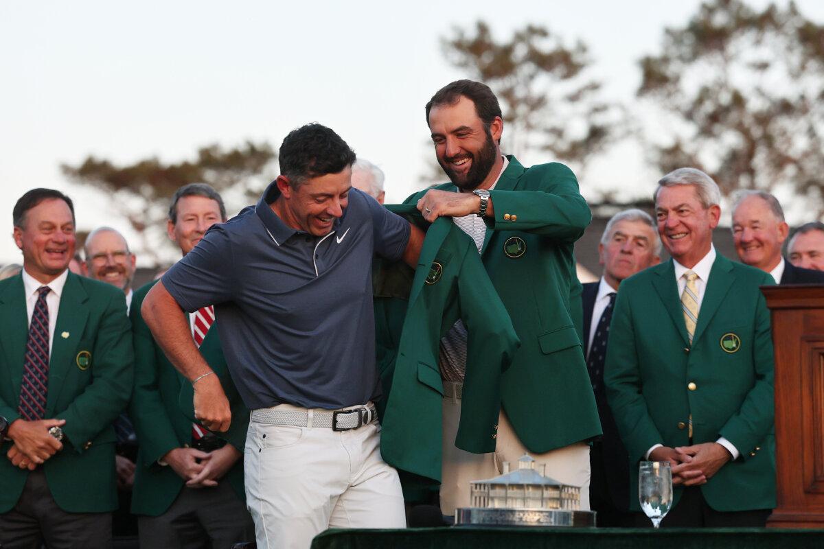 (L-R) Rory McIlroy of Northern Ireland is awarded the Green Jacket by Masters Champion Scottie Scheffler after the final round of the 2025 Masters Tournament at Augusta National Golf Club in Augusta, Georgia, on April 13, 2025. (Michael Reaves/Getty Images)