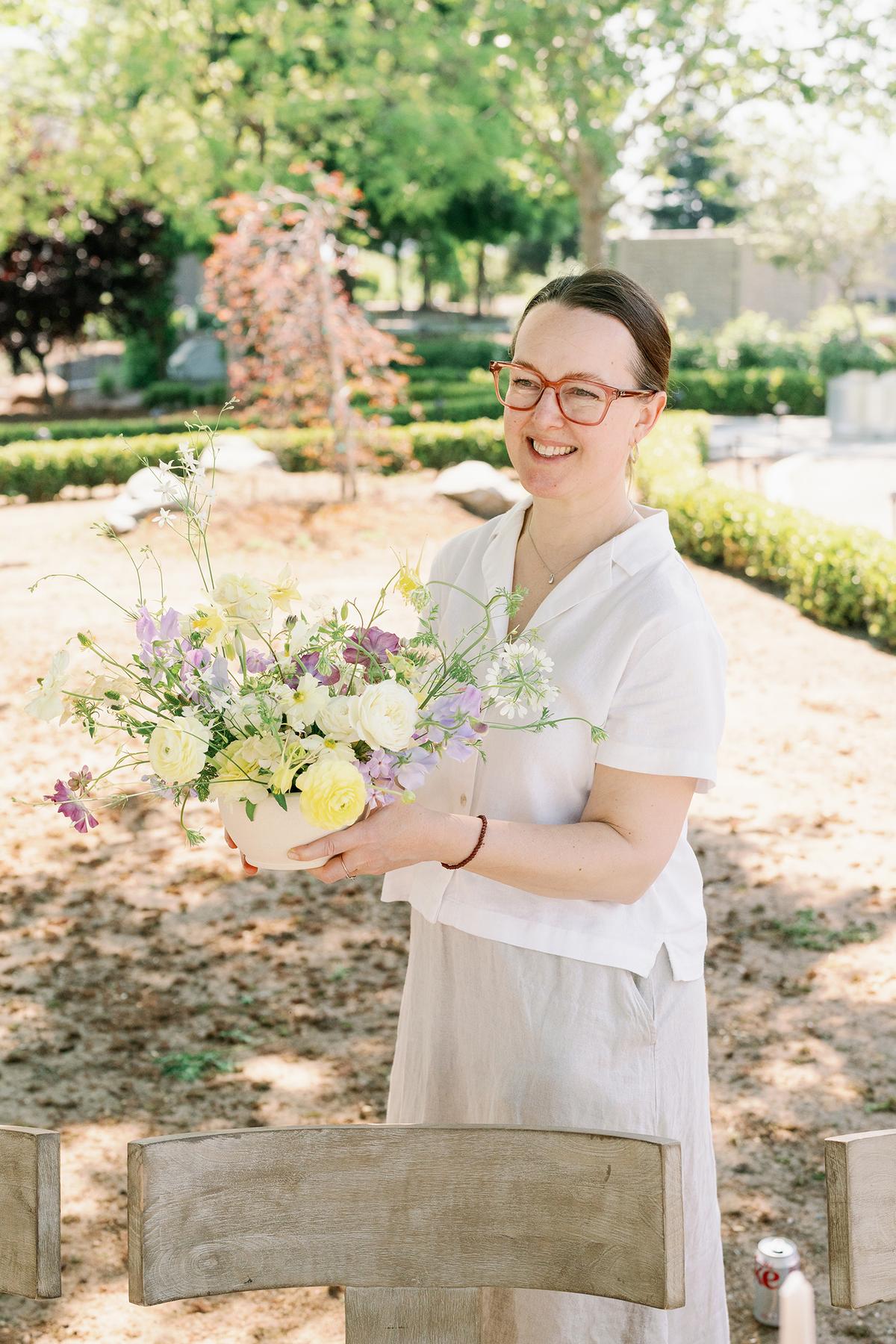 Ashley Fox with an April arrangement of ranunculus and columbine in frosted lemon and soft grape tones. (Märit Williams Photography)