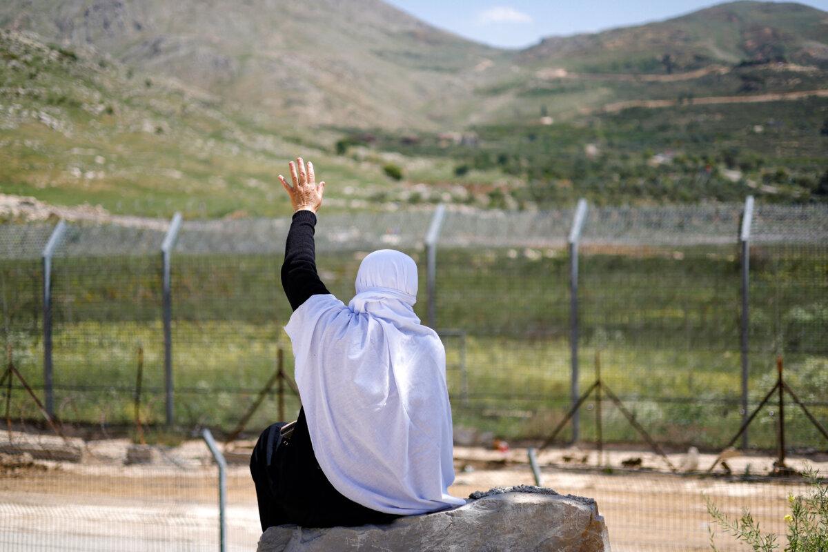 A Druze woman waves to relatives fleeing sectarian violence in Damascus, Syria, on May 3, 2025. (Jalaa Marey/AFP via Getty Images)