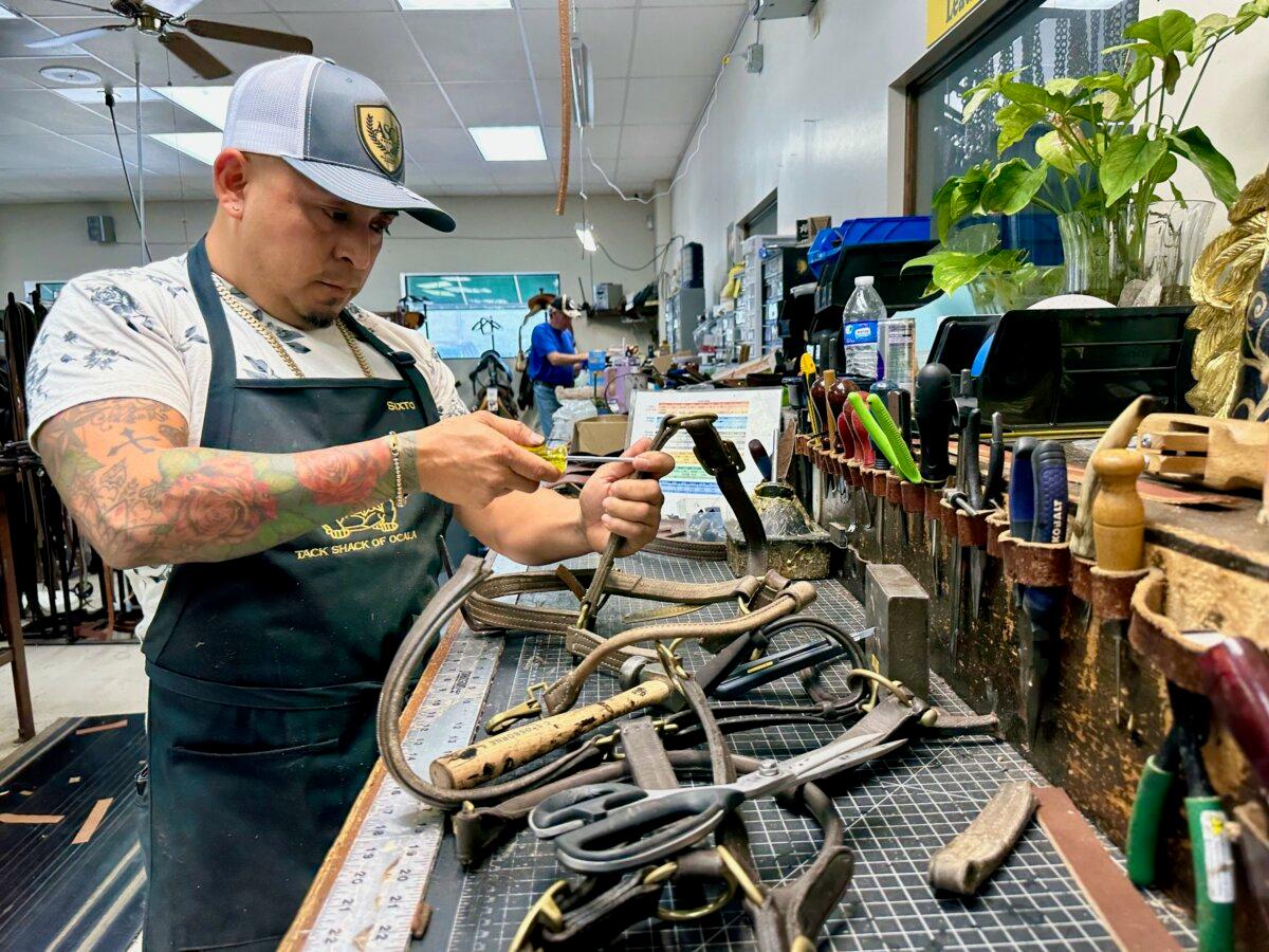 Former jockey 6to Ribera repairs thoroughbred racehorse leather halter at Ocala Tuck Shack in Ocala, Florida on April 11, 2025 (Nanette Holt/Epoch Times)