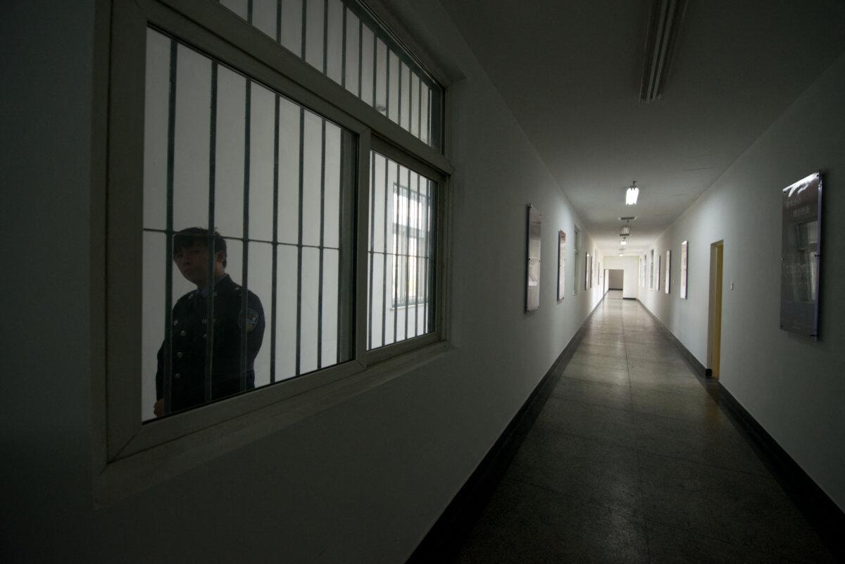 A guard looks through the window of a hallway inside a detention center in Beijing, China, on Oct. 25, 2012. (Ed Jones/AFP via Getty Images)