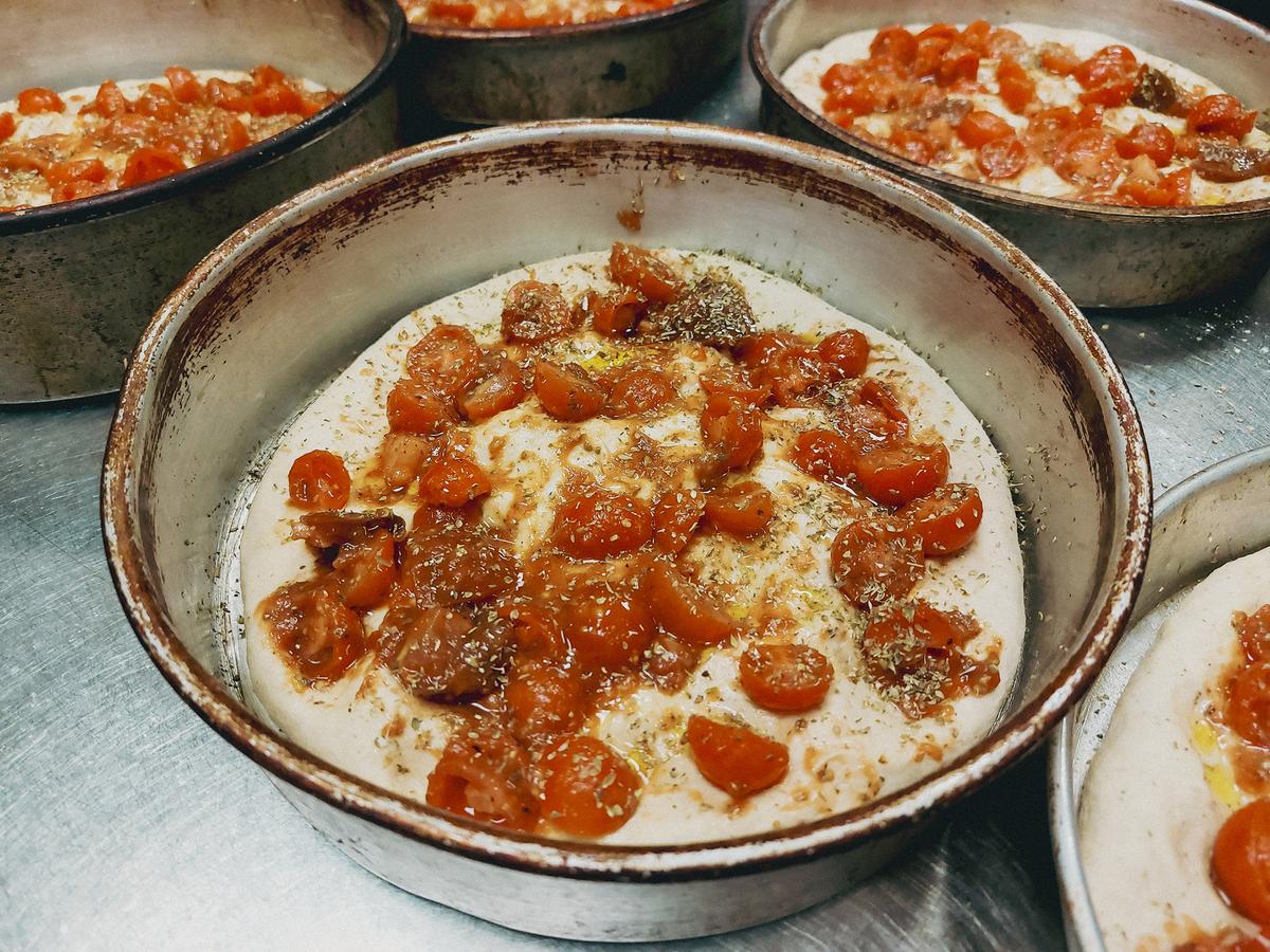 Top the dough with the cherry tomatoes, sprinkle more olive oil and oregano, then let it double in size. (Kevin Revolinski)