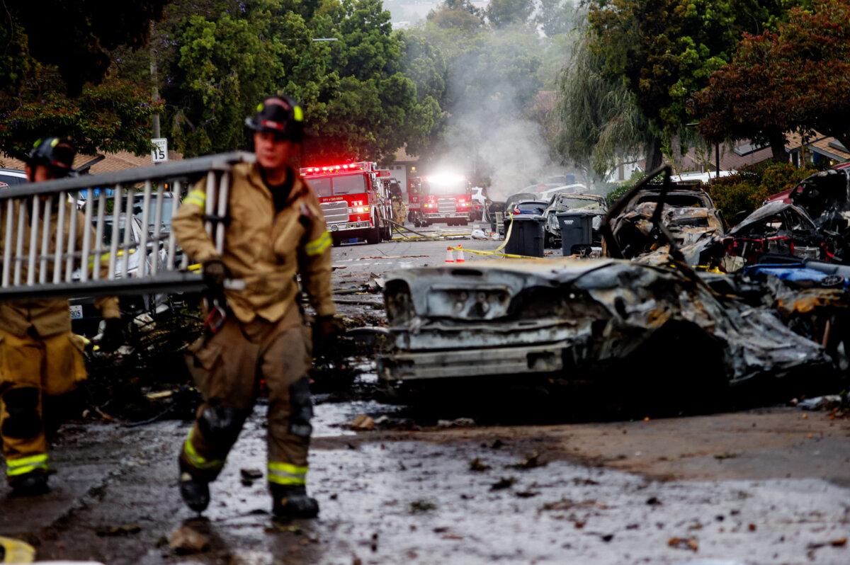 Firefighters work at a site where a small plane crashed into San Diego, California on May 22, 2025 (Sandy Huffaker/AFP via Getty Images)