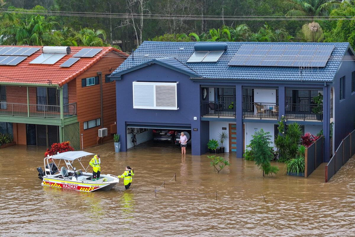 An aerial photo shows NSW Fire Rescue personnel assisting an elderly resident during flooding in Port Macquarie, New South Wales on May 22, 2025. A slow-moving trough is dumping rain along the east coast of Australia, leaving thousands of people stranded (AAP Image/Lindsay Moller)