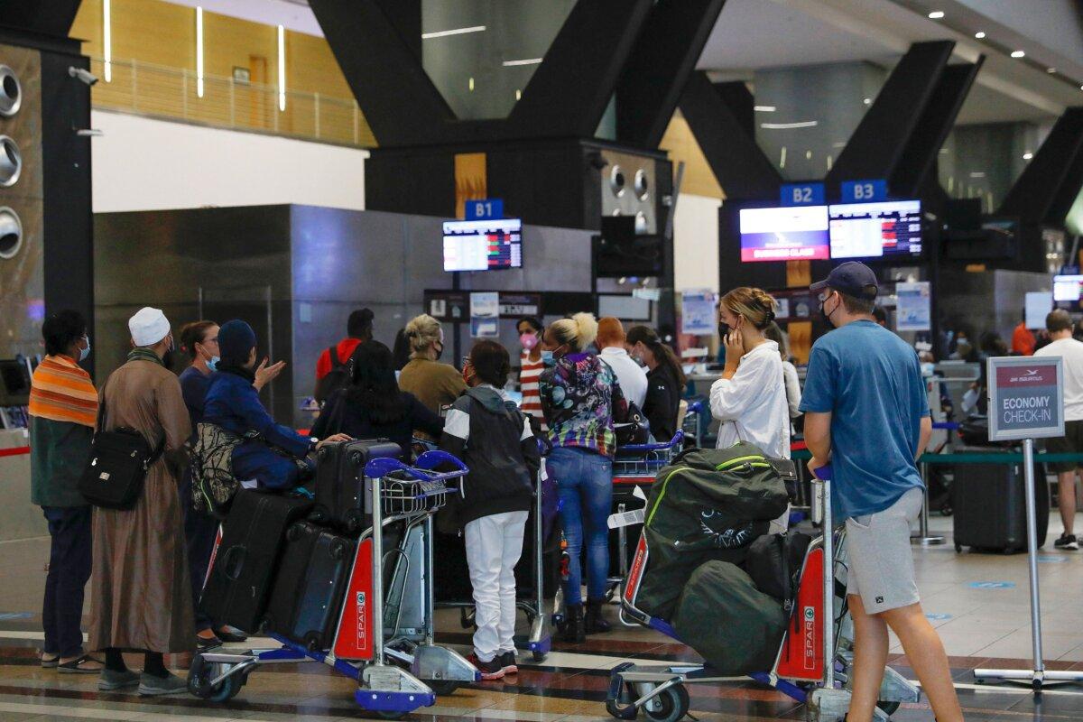 Travellers queue at a check-in counter at OR Tambo International Airport in Johannesburg, South Africa, on Nov. 27, 2021. (Phill Magakoe/AFP via Getty Images)