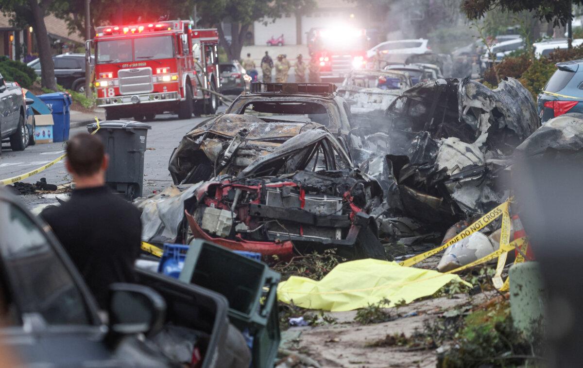 Investigators look through the site where a small plane crashed on a San Diego, California, residential street on May 22, 2025. (Sandy Huffaker/AFP via Getty Images)