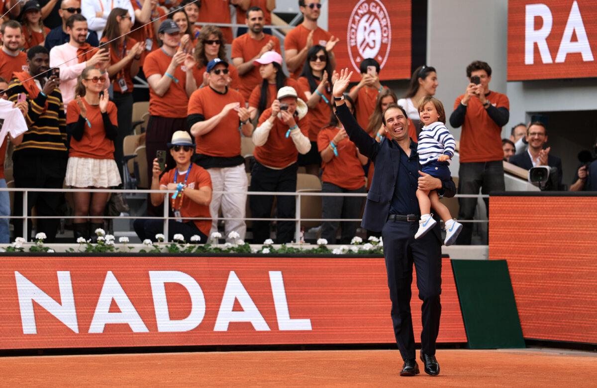 Rafael Nadal carries his son Rafael out on to Court Philippe-Chatrier during a ceremony held in his honor on Day One of the 2025 French Open at Roland Garros in Paris, France, on May 25, 2025. (Adam Pretty/Getty Images)