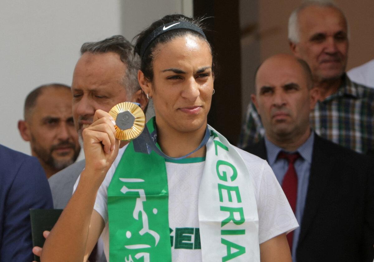 Algerian boxer Imane Khelif, who won the gold medal in the women's welterweight boxing at the Olympics, holds a medal upon arrival at the airport in Algiers, Algeria, on Aug. 12, 2024. (Ramzi Boudina/Reuters)