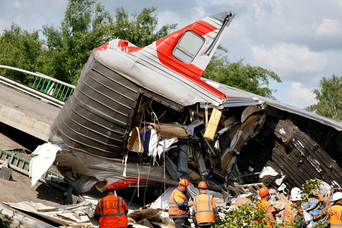 Ukraine Launches Drone Strikes on Air Bases Deep Inside Russia | USNN World News Specialists of emergency services gather near a destroyed carriage at the scene, after a road bridge collapsed onto railway tracks derailing an approaching train in the Bryansk region, Russia, on June 1, 2025. (Stringer/Reuters)