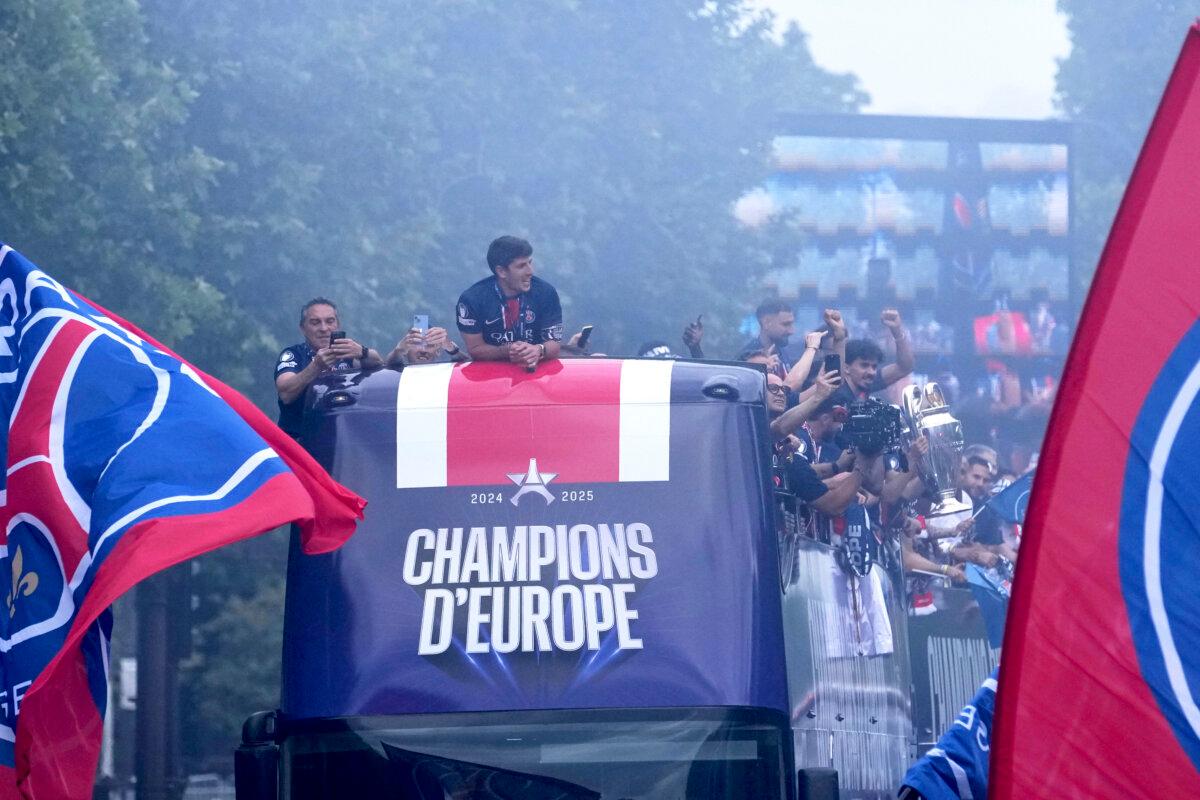 PSG players present the trophy to supporters during a parade on the Champs-Élysées avenue after the team won the Champions League final soccer match between Paris Saint-Germain and Inter Milan, in Paris on June 1, 2025. (Thibault Camus/AP Photo)
