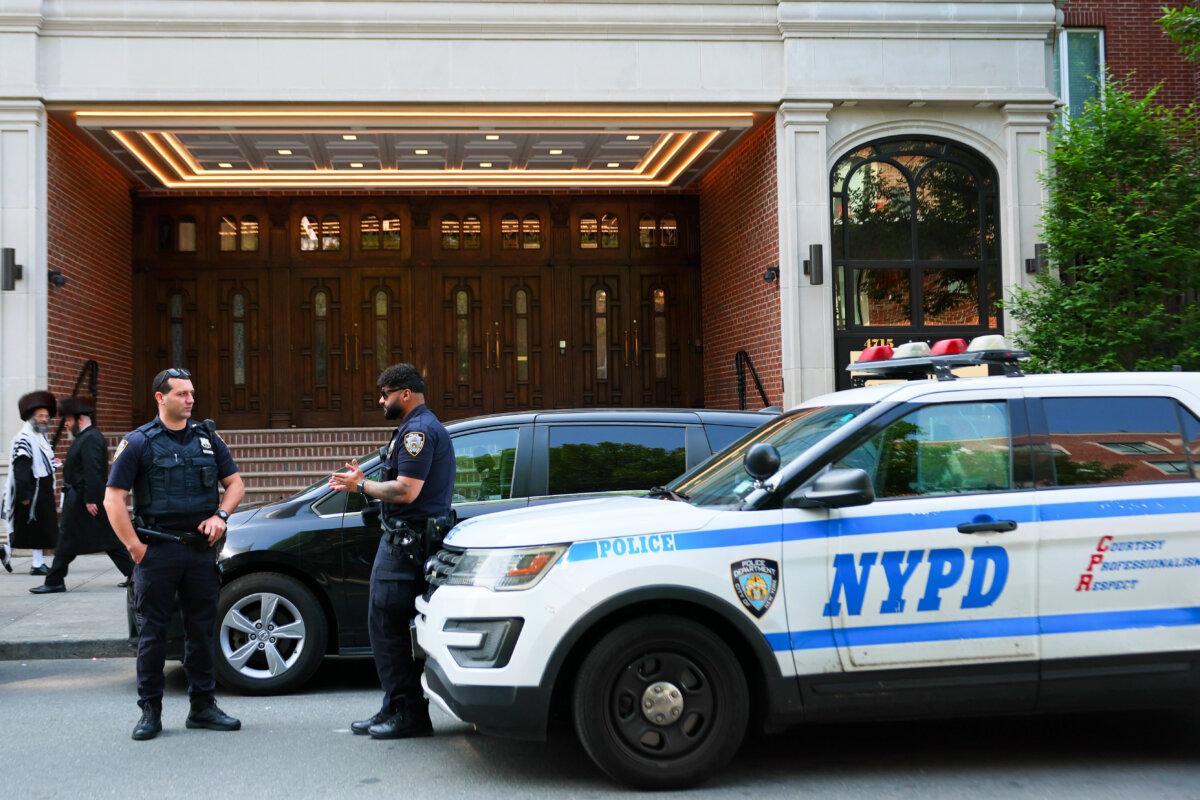 Members of the Orthodox Jewish community walk past NYPD officers in the Borough Park neighborhood of New York City on June 02, 2025. (Michael M. Santiago/Getty Images)