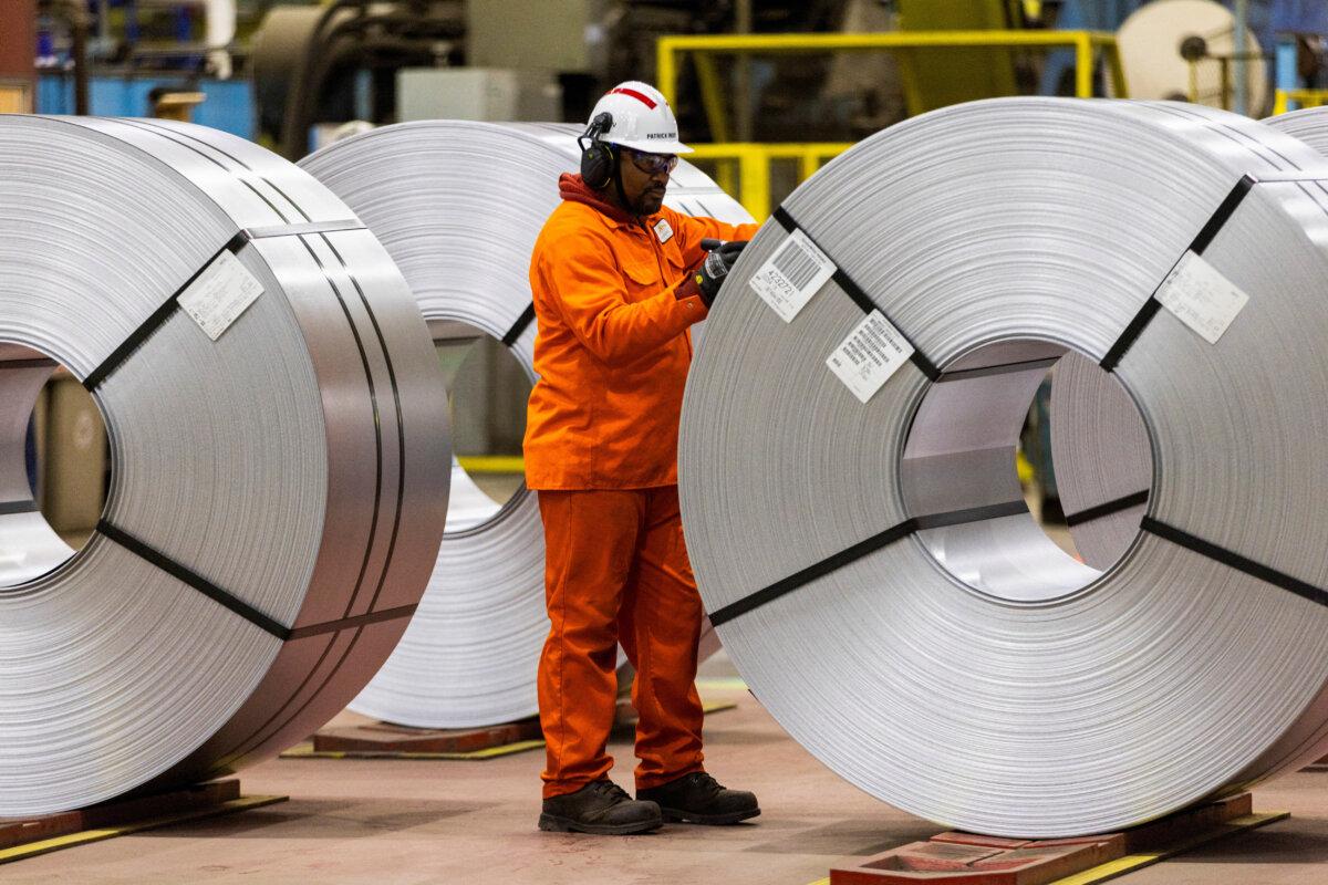 A worker inspects a steel coil on the factory floor before Prime Minister Mark Carney visits the ArcelorMittal Dofasco steel mill in Hamilton, Ont., on March 12, 2025. (Carlos Osorio/Reuters)
