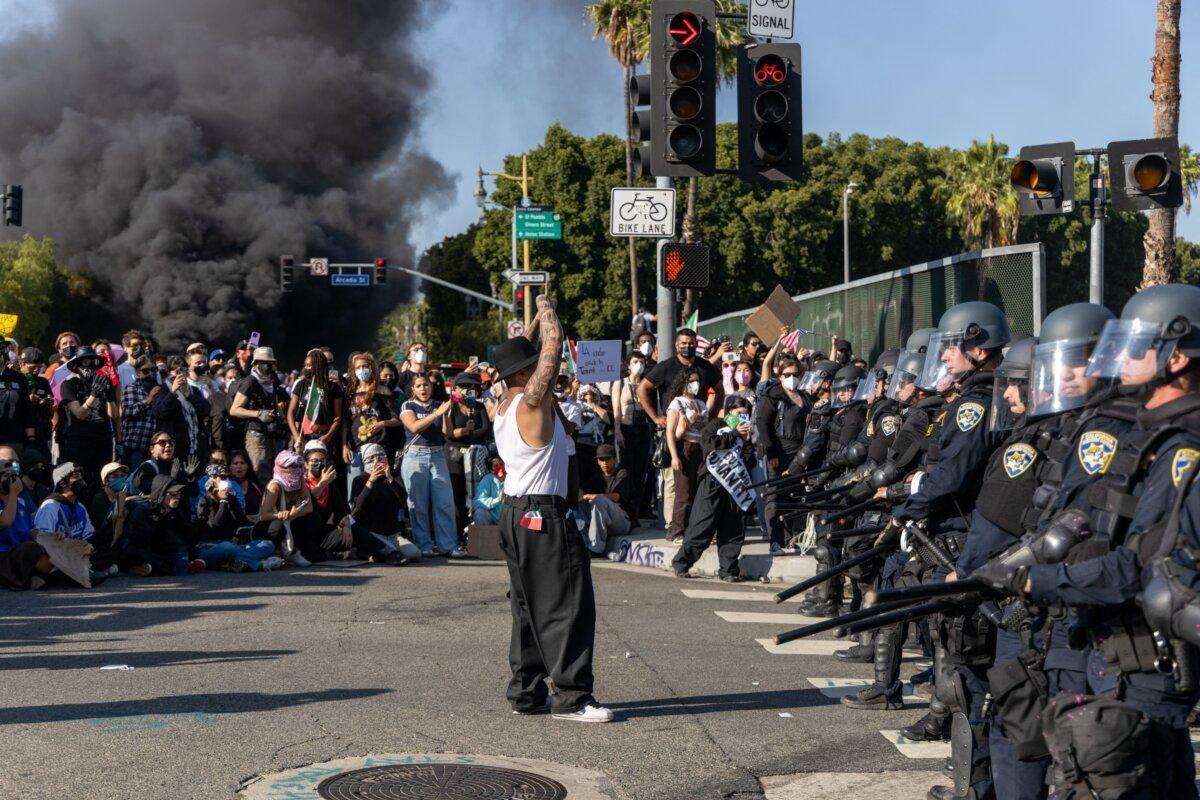A protester stands in front of a police line in Los Angeles, Calif., on June 8, 2025. (Lauren Puente/Middle East Images/AFP via Getty Images)