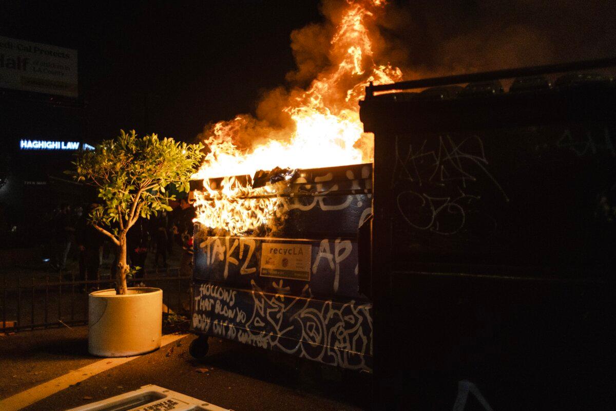 FBI Investigating Money Trail Behind Los Angeles Riots, Patel Says | USNN World News Protesters set a dumpster on fire during clashes with police in downtown Los Angeles on June 8, 2025. (Jim Vondruska/Getty Images)