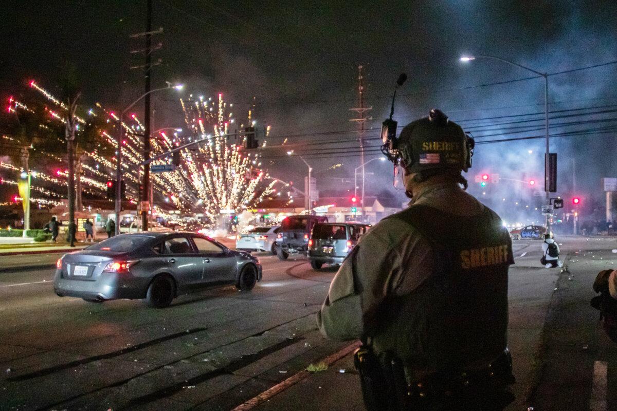 A firework explodes near L.A. County sheriff's deputies in Paramount, Calif., on June 7, 2025. (Apu Gomes/Getty Images)