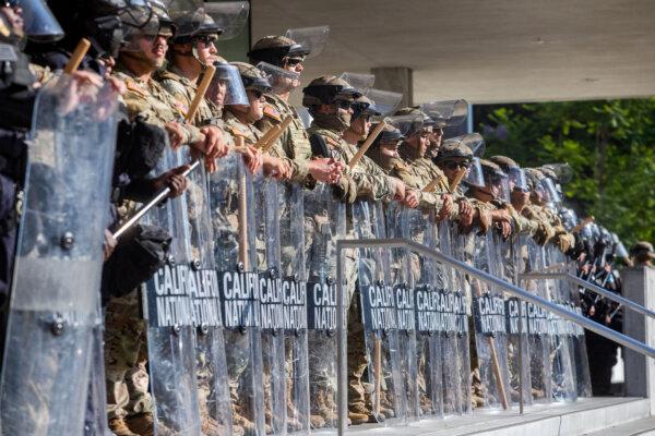 California National Guard members stand outside the federal building in Los Angeles on June 10, 2025, as people protest federal immigration operations. (Apu Gomes/AFP via Getty Images)