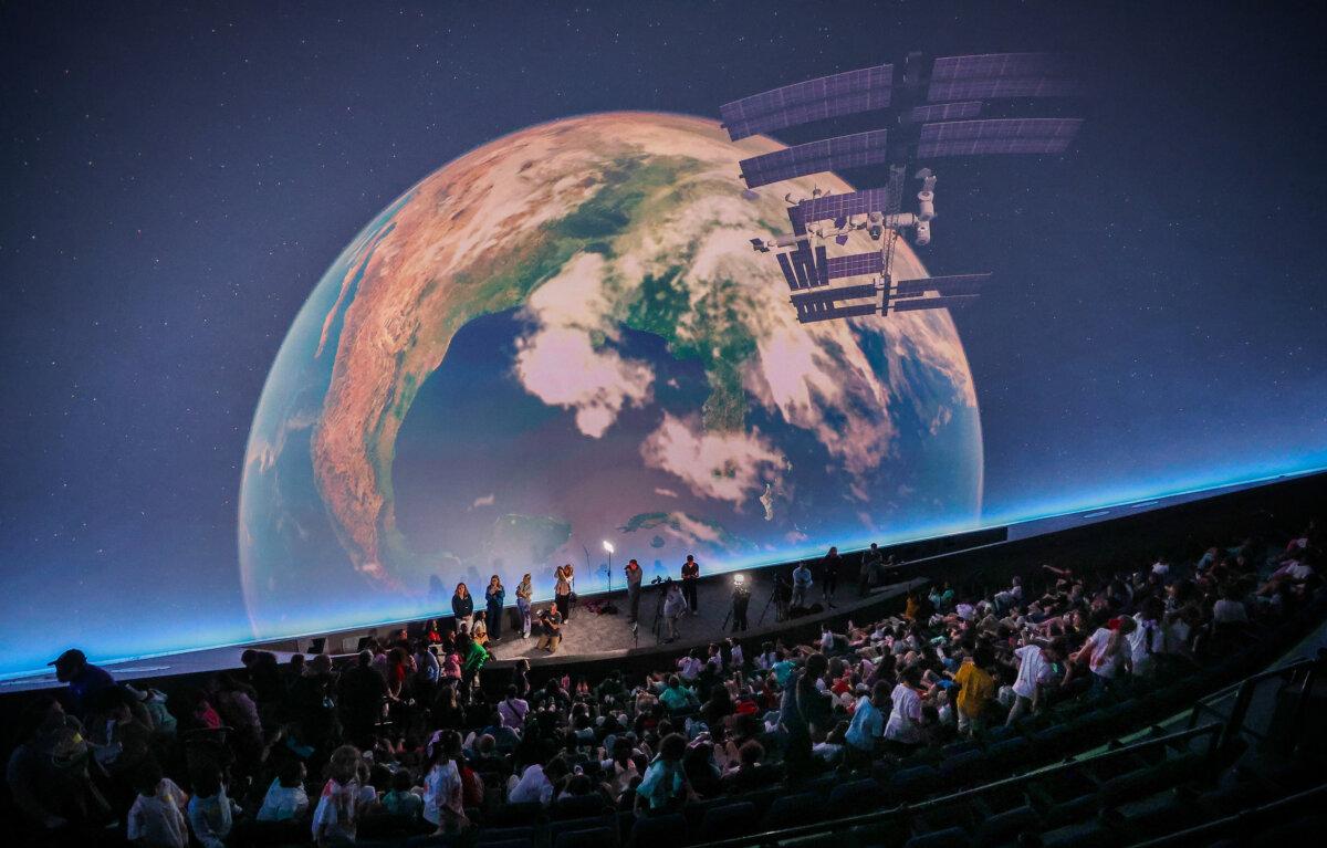 The Earth and the International Space Station are on the screen as Hillsborough County students pack the new Digital Dome Theatre. They were there for the first-ever field trip to the new planetarium at the Museum of Science and Industry, in Tampa, Florida, on March 31, 2025. (Dirk Shadd/Tampa Bay Times/TNS)