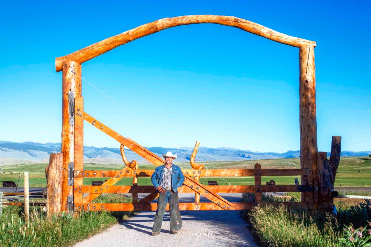 Jess Oldham stands in front of the entrance gate to Wind River Wild Horse Sanctuary. (Maria Coulson)