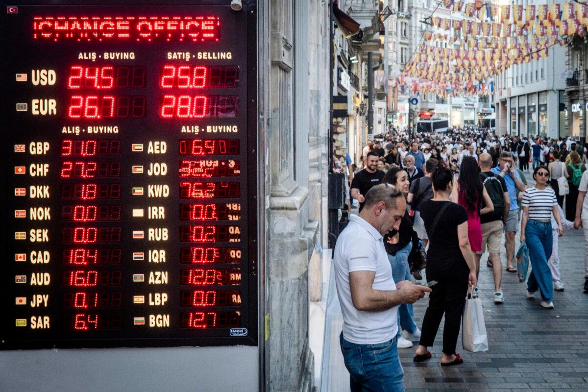 People walk past a currency exchange shop in Istanbul on June 23, 2023. (Chris McGrath/Getty Images)