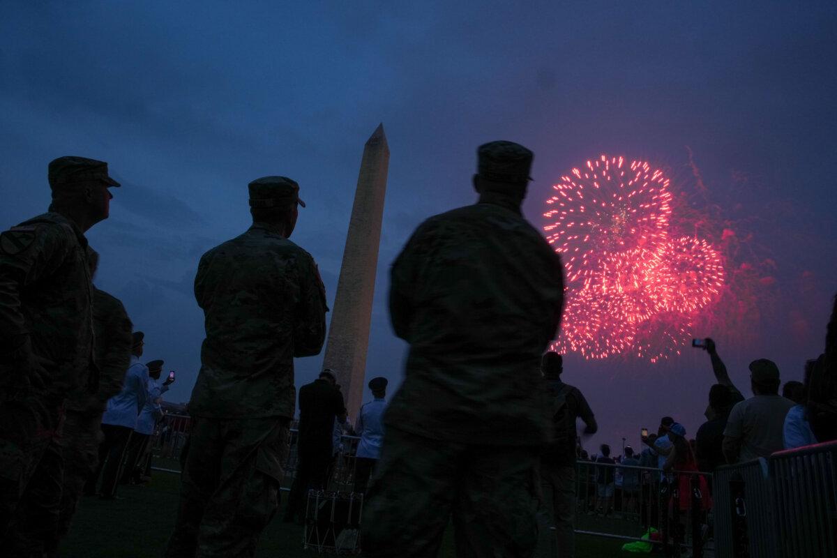 People watch as fireworks explode near the Washington Monument during the U.S. Army's 250th birthday celebration in Washington on June 14, 2025. (Andrew Harnik/Getty Images)