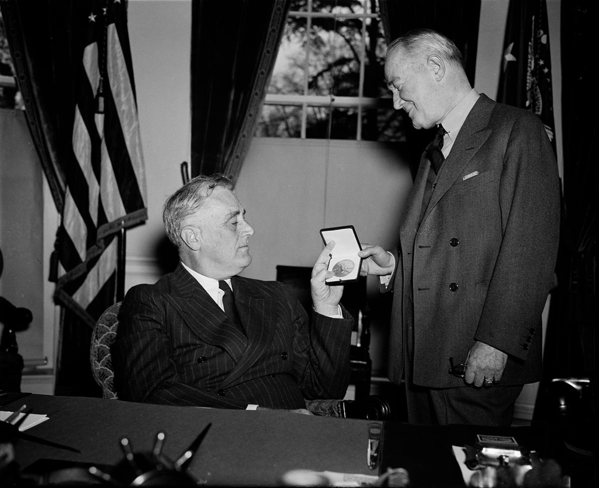 President Roosevelt presents a gold medal to George M. Cohan in recognition for his two patriotic songs “Their Hearts are Over Here” and “You’re a Grand Old Flag” on May 1, 1940. Library of Congress. (Public Domain)