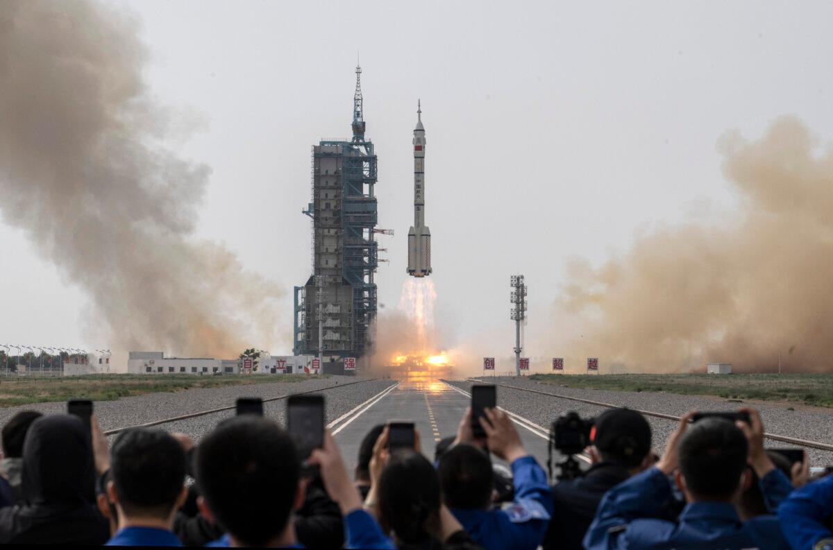 People watch as the Shenzhou-16 spacecraft onboard the Long March-2F rocket launches in Jiuquan, China, on May 30, 2023. (Kevin Frayer/Getty Images)