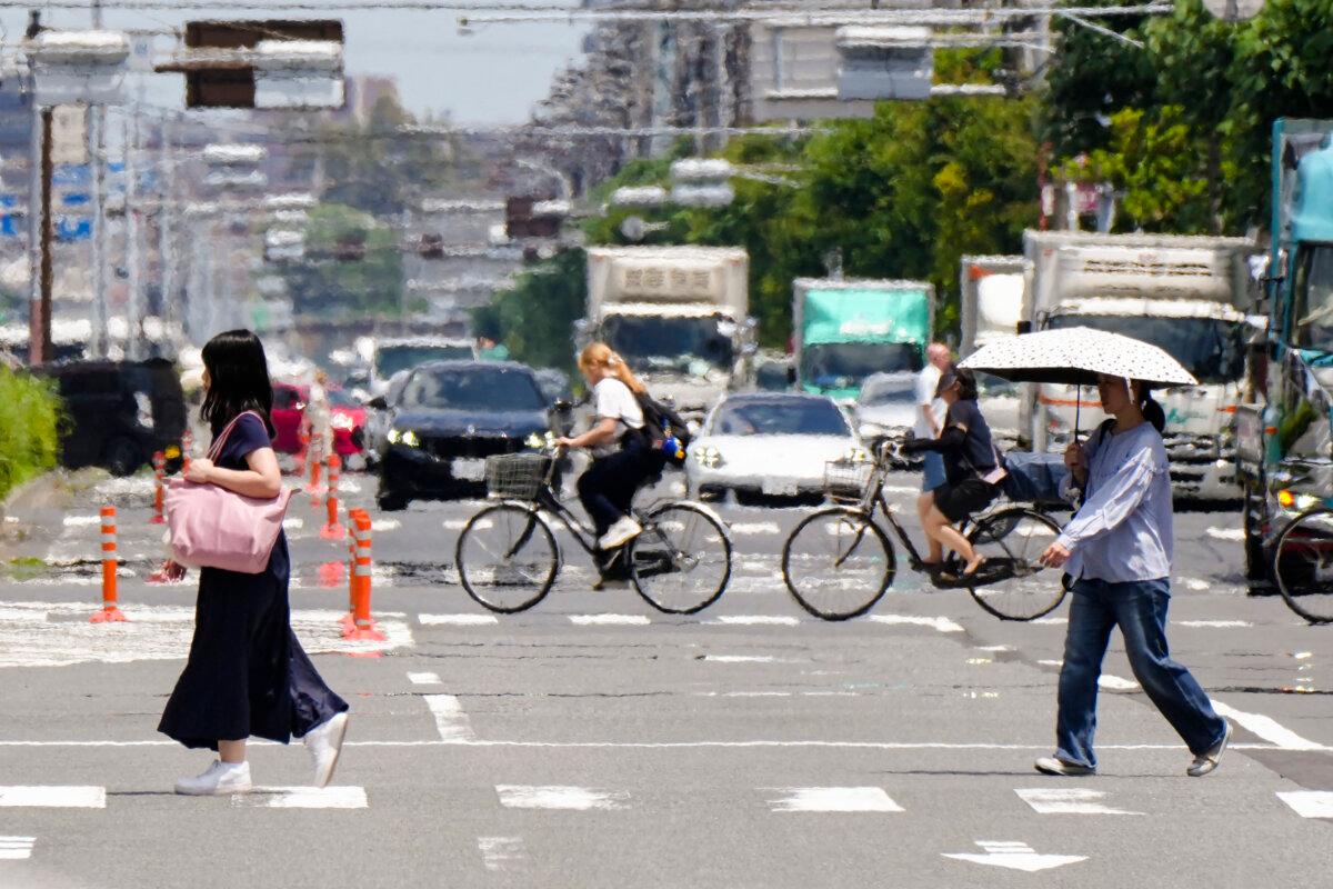 People cross a street under the hot sun in Tokyo on June 20, 2025. (Kazuhiro Nogi/AFP via Getty Images)