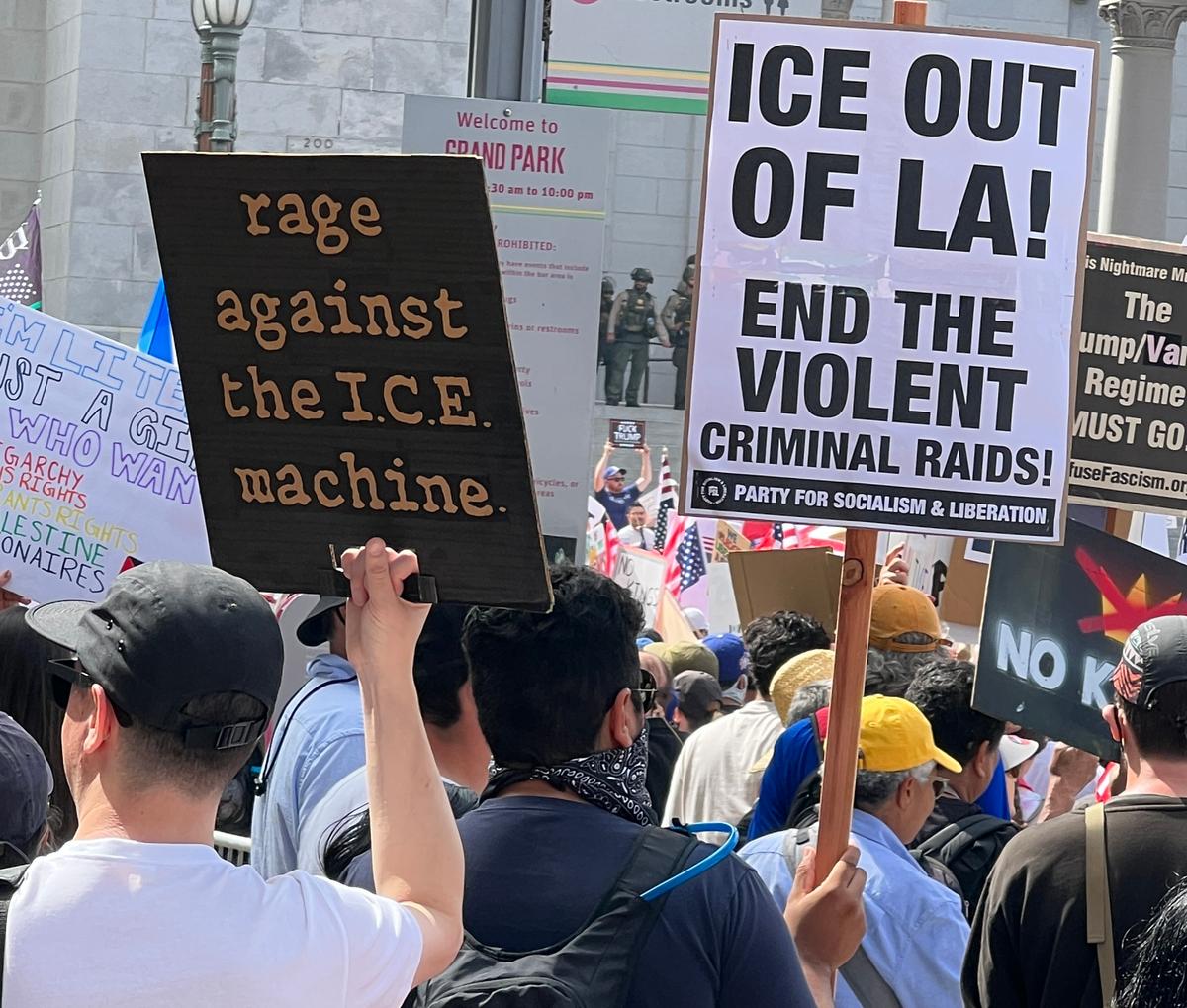 A protester carries a black-and-white Party for Socialist and Liberation (PSL) sign at the No Kings protest at Los Angeles City Hall, Calif., on June 14, 2025. (Brad Jones/The Epoch Times)