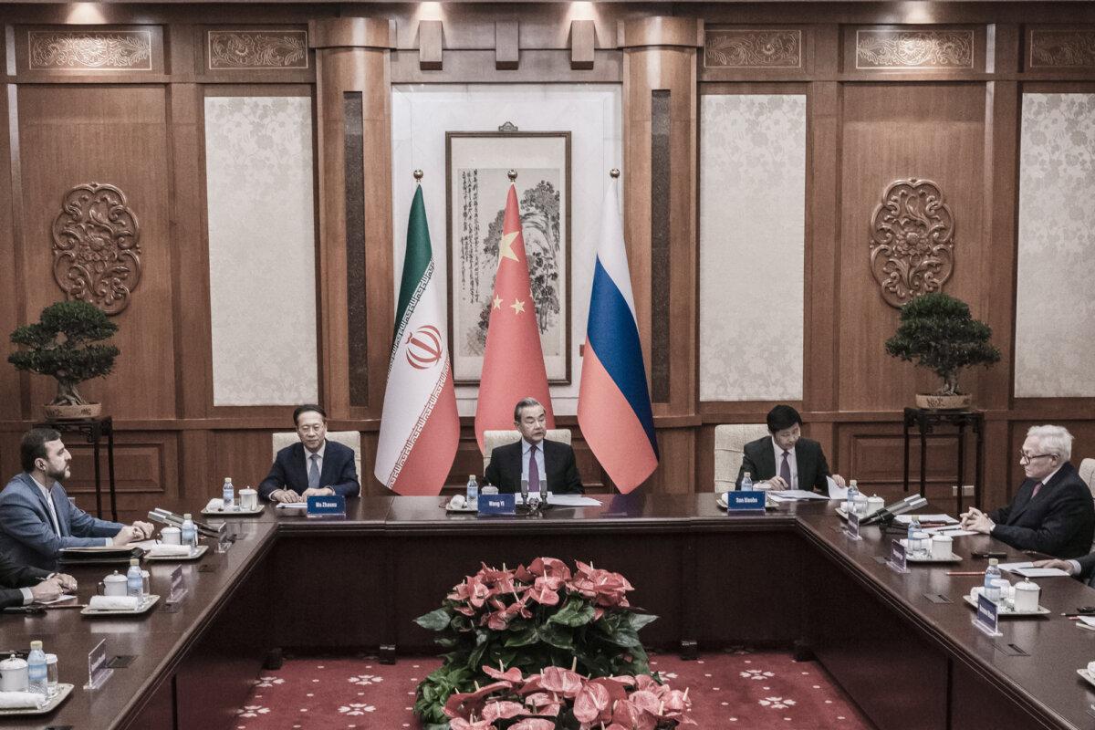 Chinese Foreign Minister Wang Yi (C) sits at the head of a meeting with Russian Deputy Foreign Minister Sergei Ryabkov (R) and Iranian Deputy Foreign Minister Kazem Gharibabadi (L) during a meeting in Beijing on March 14, 2025. (Stringer/Getty Images)