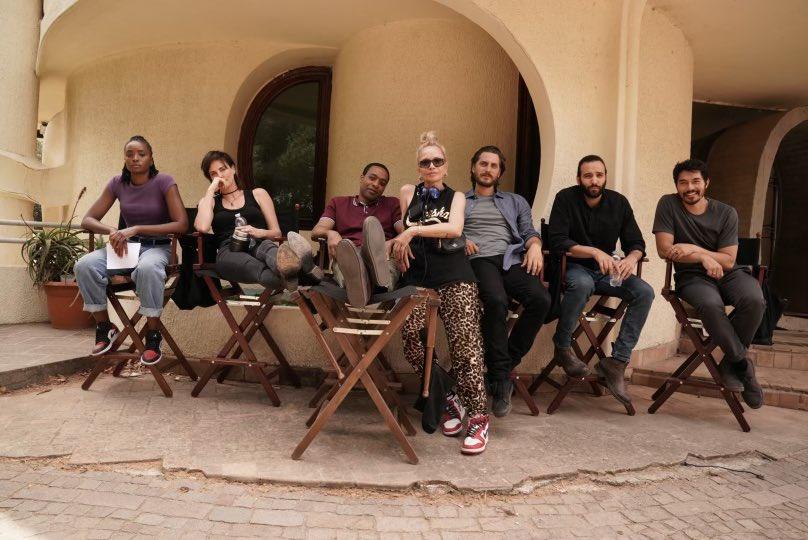 (L–R) Kiki Layne, Charlize Theron, Chiwetel Ejiofor, director Victoria Mahoney, Luca Marinelli, Marwan Kenzari, and Henry Golding on the set of “The Old Guard 2." (Netflix)