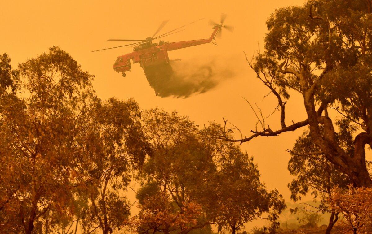 A water bombing helicopter drops water over bushfires near Bumbalong, Australia, on Feb. 1, 2020. (Peter Parks/AFP via Getty Images)