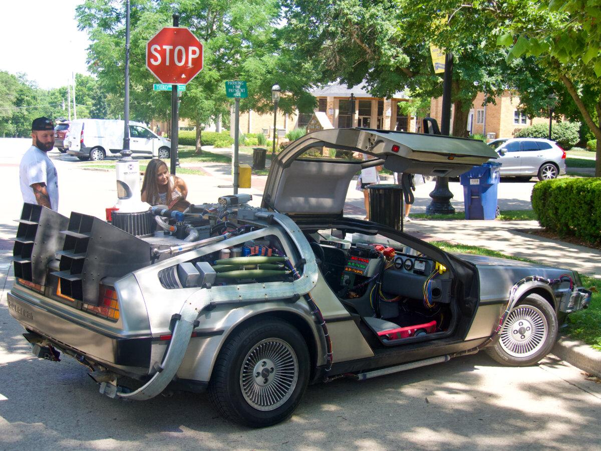 Within minutes of parking the DeLorean "time machine" built to resemble the car from the "Back to the Future" movie franchise, dozens of pedestrians stopped to look and take pictures, near Chicago, Ill., on July 1, 2025. (Travis Gillmore/The Epoch Times)