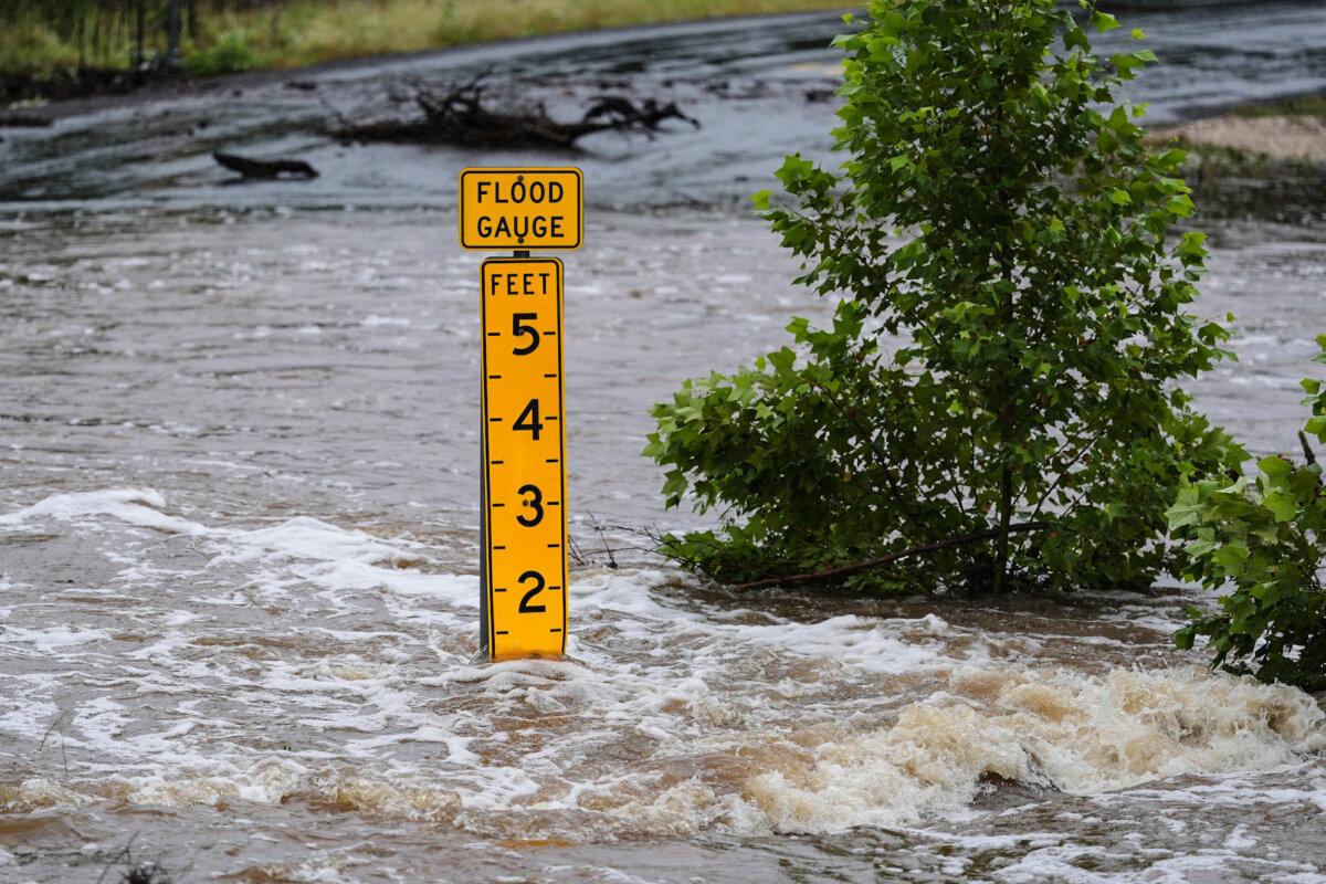 24 Dead, 20 Girls Missing as Flooding Ravages Central Texas 2 A flood gauge marks the height of water flowing over a farm-to-market road near Kerrville, Texas, on July 4, 2025. (Eric Gay/AP Photo)
