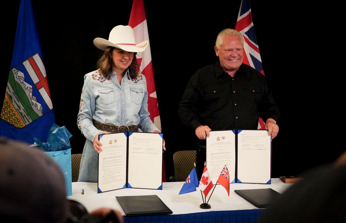 Alberta Premier Danielle Smith and Ontario Premier Doug Ford hold signed memorandums of understanding between the two provinces in Calgary on July 7, 2025. (Carolina Avendano/The Epoch Times)