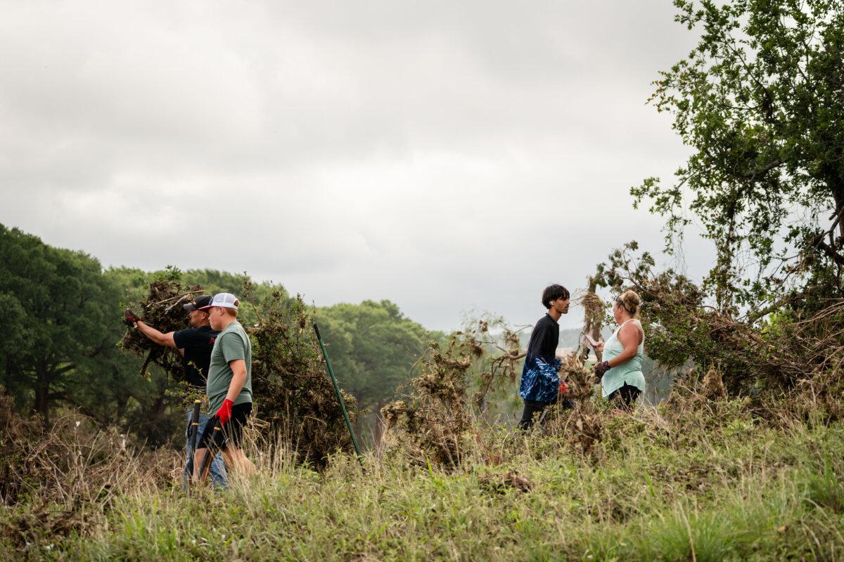 Vinnie Mifsud’s family and friends help clean up the area of his RV business in the aftermath of recent floods in Kerrville, Texas, on July 9, 2025. (Madalina Kilroy/The Epoch Times)