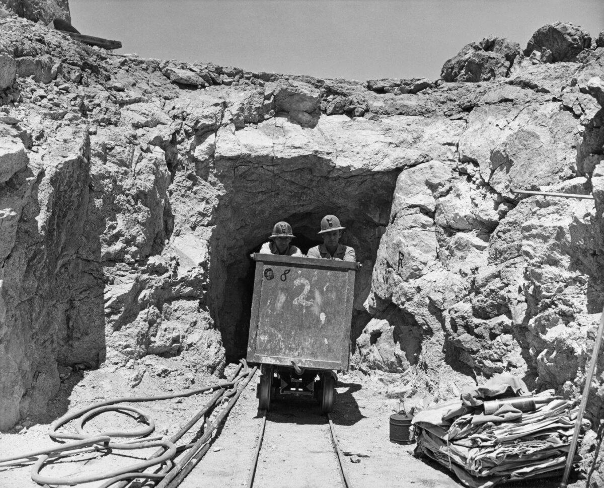 Two miners push an ore cart as they emerge from a uranium mine in California, circa 1955. (Tom Stimson/FPG/Archive Photos/Getty Images)