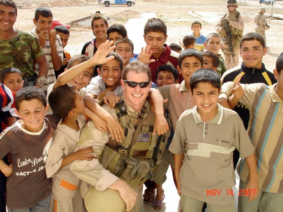 Doolittle (C) surrounded by kids in Ramadi, Iraq, after the opening of a coalition-founded school in 2007. (Courtesy of John Doolittle)