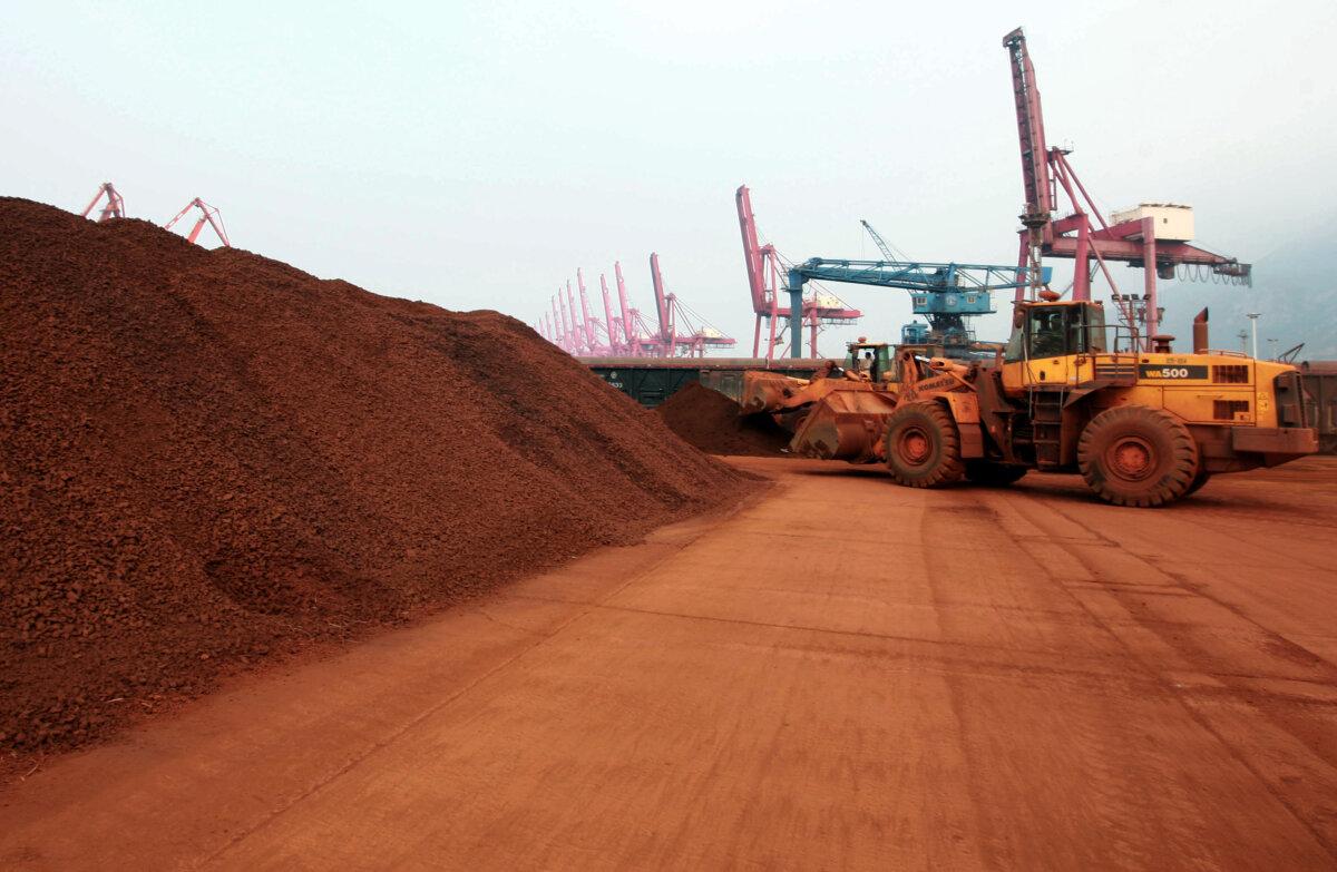 A man driving a front loader shifts soil containing rare-earth minerals at a port in Lianyungang, China's Jiangsu province, on Sept. 5, 2010. (AFP via Getty Images)