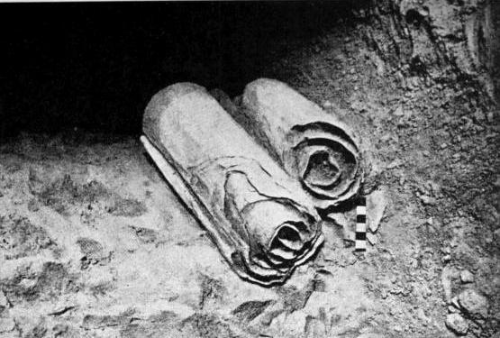 Two scrolls from the Dead Sea Scrolls lie at their location in the Qumran Caves before being removed for scholarly examination by archaeologists. (Public Domain)