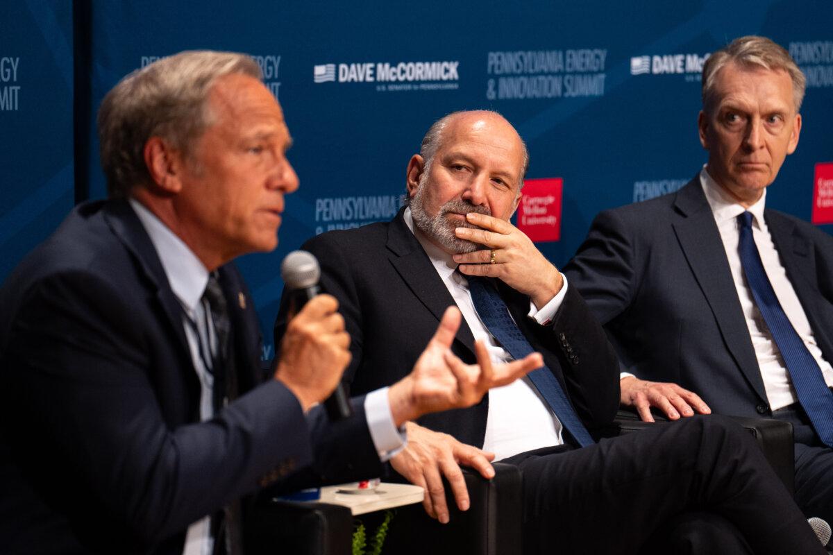 Secretary of Commerce Howard Lutnick (C) listens as Mike Rowe, chief executive officer at mikeroweWORKS Foundation, speaks at the Pennsylvania Energy and Innovation Summit at Carnegie Mellon University in Pittsburgh on July 15, 2025. (Samira Bouaou/The Epoch Times)
