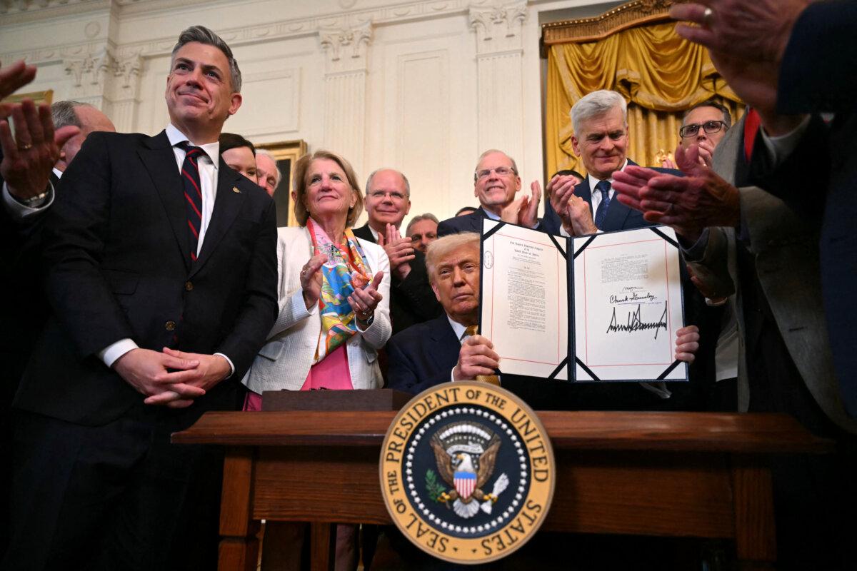 President Donald Trump holds up the "Halt All Lethal Trafficking of Fentanyl Act," which strengthens prison sentences for fentanyl traffickers, after signing it in the East Room of the White House on July 16, 2025. (Andrew Caballero-Reynolds/AFP via Getty Images)