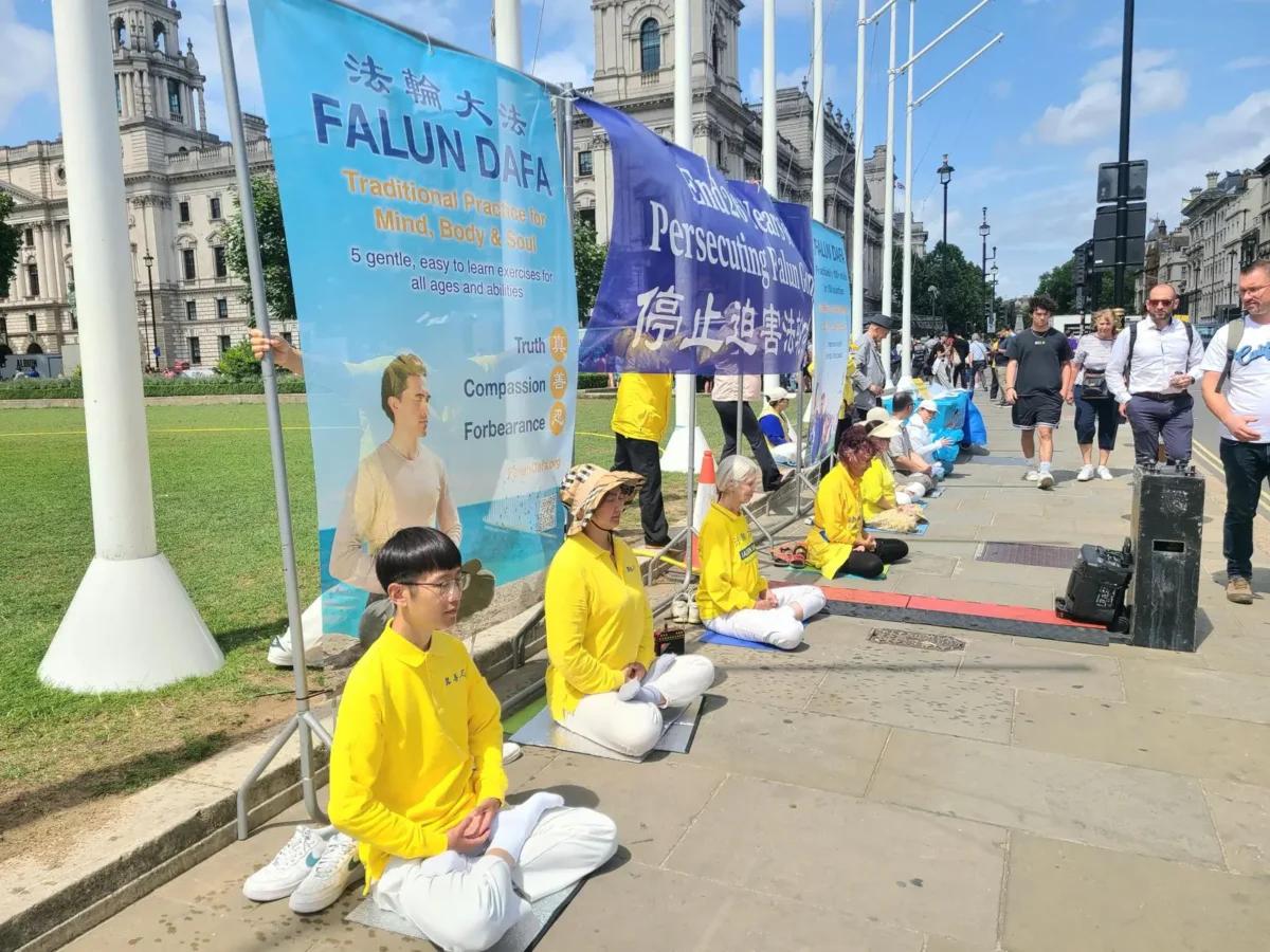 Falun Gong practitioners hold a peaceful demonstration outside the UK Parliament on July 15, 2025. (Yueyang Lee/The Epoch Times)