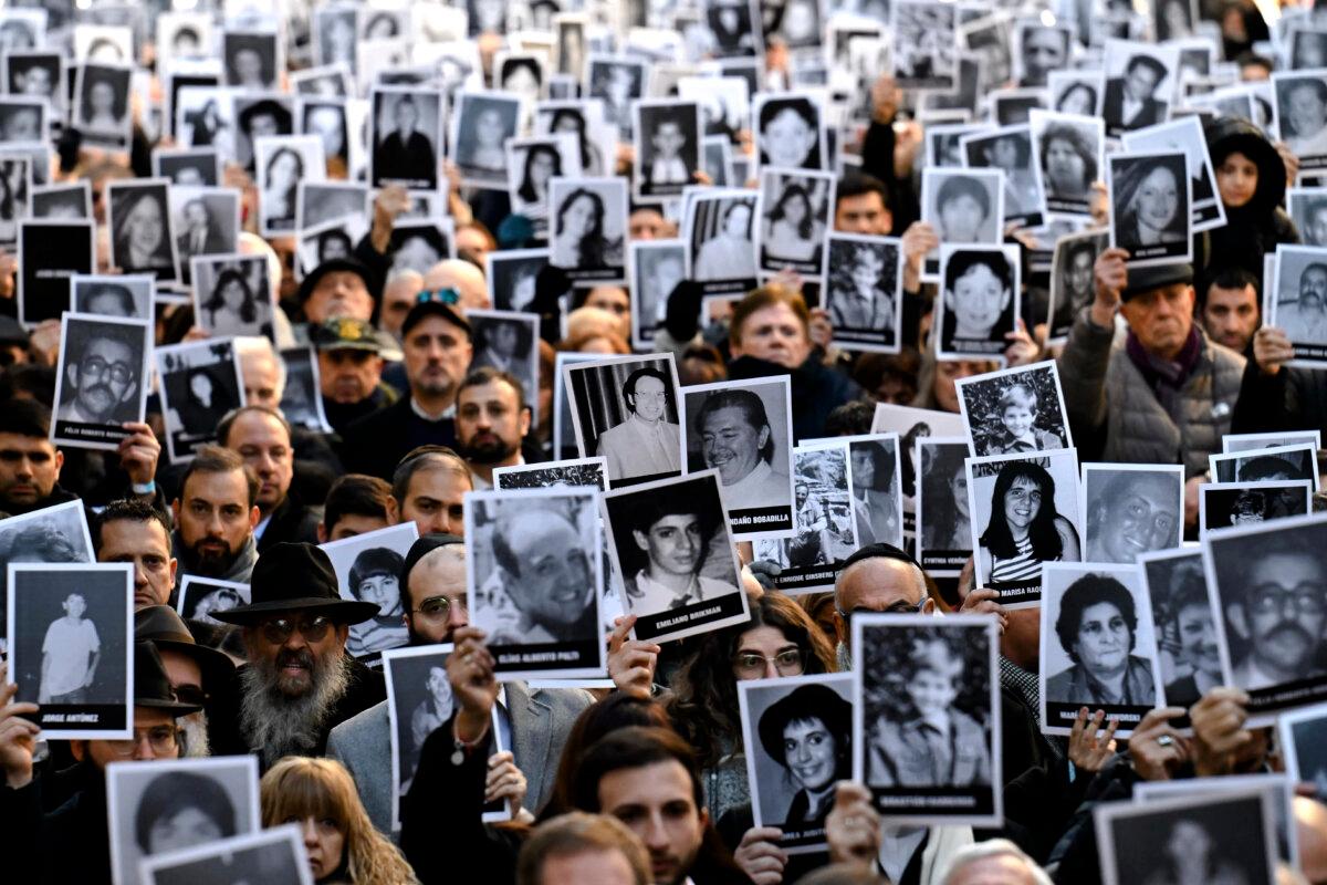 People hold pictures of victims during a ceremony to commemorate the 31st anniversary of the Mutual Israelite Association of Argentina bombing attack, which left 85 dead and more than 300 wounded, in Buenos Aires, Argentina, on July 18, 2025. (Luis Robayo/AFP via Getty Images)
