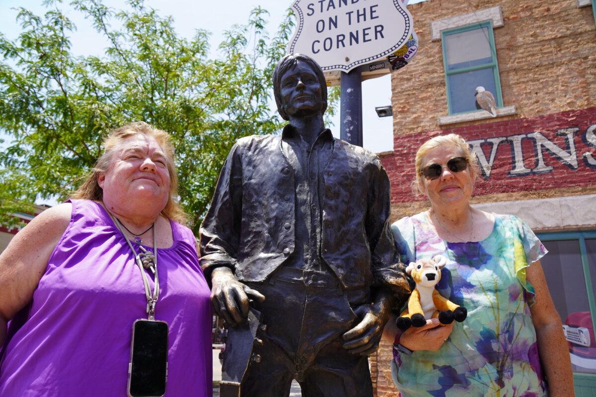 Sisters Rebecca Houston (L) and Deb Good pose for a selfie in front of a statue of singer Jackson Browne on July 16, 2025. (Allan Stein/The Epoch Times)