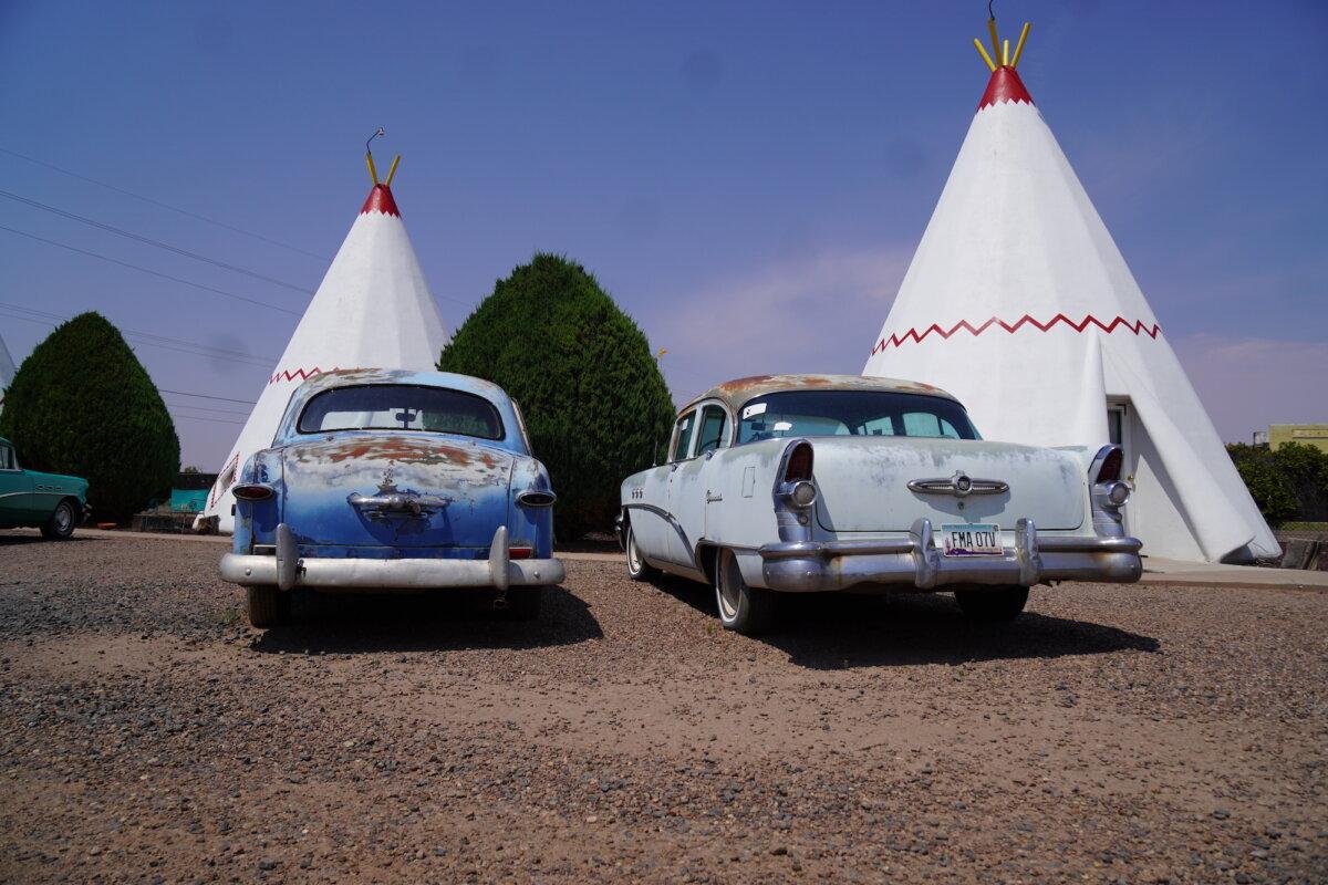 Vintage cars sit parked in front of a wigwam hotel off Historic Route 66 in Holbrook, Ariz., on July 16, 2025. (Allan Stein/The Epoch Times)